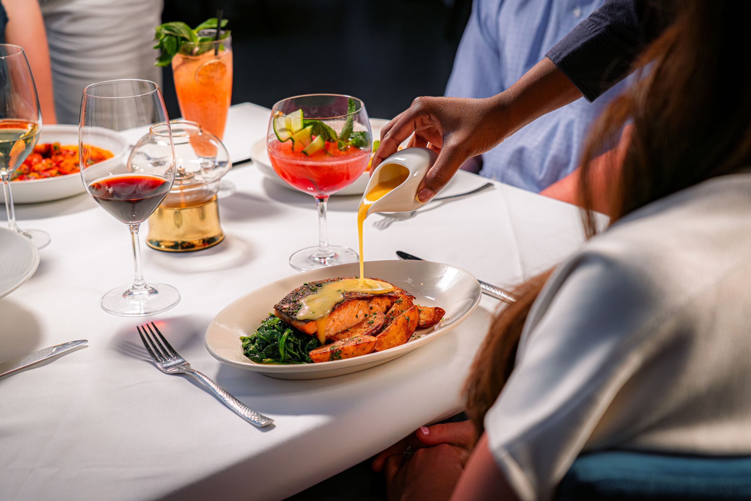 Lemon butter sauce poured tableside over salmon with steakhouse potatoes at Casa Mangiare